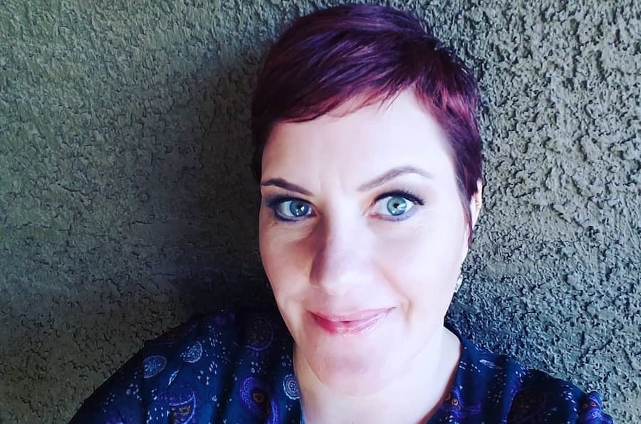Court Harler headshot, with a with pixie-cut red hair and blue-green eyes.